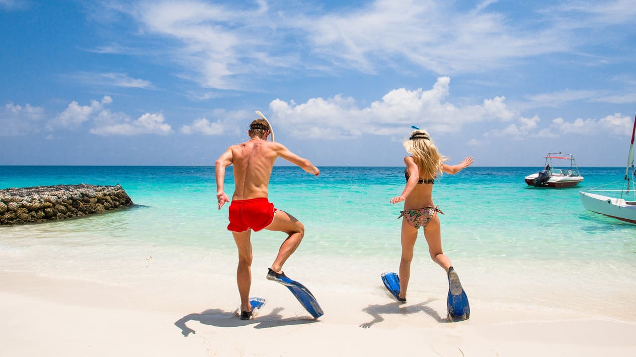 Couple on a Seychelles honeymoon splashing into ocean