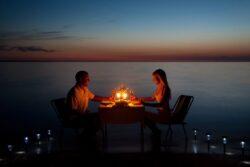 Couple have candlelit dinner on beach 